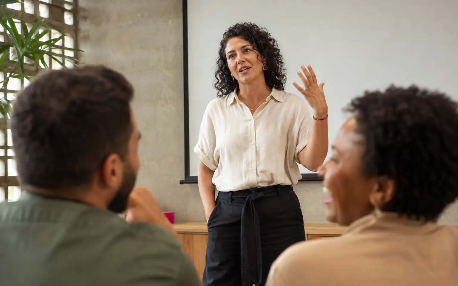Participante de pé apresentando para a turma sentada durante o treinamento
